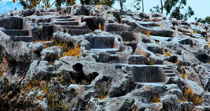 Stone steps leading up at Qenqo, Cusco, Peru, showcasing ancient architecture and natural surroundings.