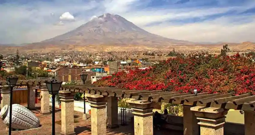 A perspective from a colonial balcony, showing the unique architecture of the city of Arequipa and its impressive skyline with the Misti volcano.